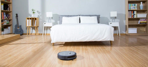 A roborock vacuum is cleaning the hardwood floor