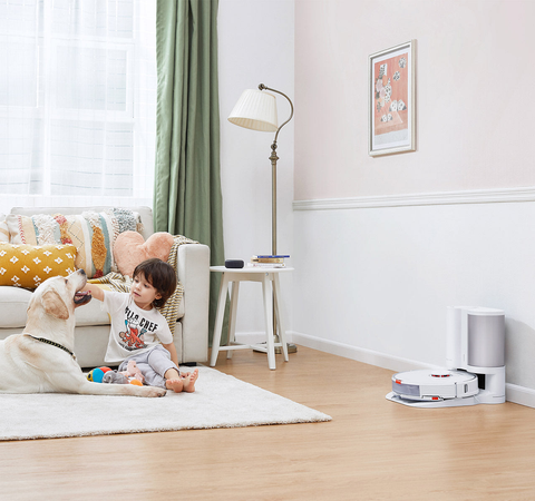 A white Roborock robotic vacuum S7 with charging base in the middle of the bedroom